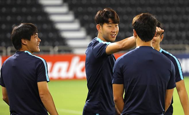 손흥민이 2018 러시아월드컵 최종예선 카타르 전을 하루 앞둔 12일 오후(현지시간) 카타르 도하 자심 빈 하마드 경기장에서 열린 축구국가대표팀 훈련에서 패스 게임 도중 실수한 황희찬에게 애정어린 꿀밤을 주고 있다.[연합뉴스]