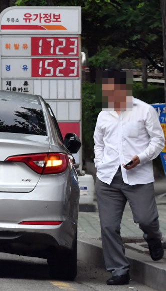 경유, 驚油?  - 정부가 휘발유의 85% 수준인 경유 가격을 최소 90% 이상으로 올리는 방안을 논의하고 있다. 담뱃세에 이어 서민 증세 논란이 다시 고개를 들 수 있다는 우려가 나온다. 한 시민이 25일 서울 여의도의 주유소 앞을 지나가고 있다.박지환 기자 popocar@seoul.co.kr