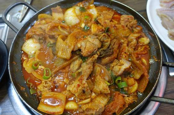 돼지고기두루치기 밑바닥을 들추면 김치 줄기가 여러 가닥 올라온다.