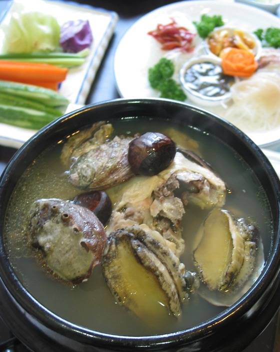 한약재와 채소를 달인 국물에 생 닭, 큼직한 전복을 껍데기까지 넣고 끓인 ‘해천탕’. 1996년 전복 전문 음식점 ‘해천’에서 개발한 음식이다. 전통 보양식으로 알고 있는 경우가 많지만 올해 나이가 스물한 살밖에 안 된 젊은 음식이다. 사진은 2004년 이태원 '해천’에서 촬영한 해천탕이다. 지금도 달라지진 않았다.[중앙포토]