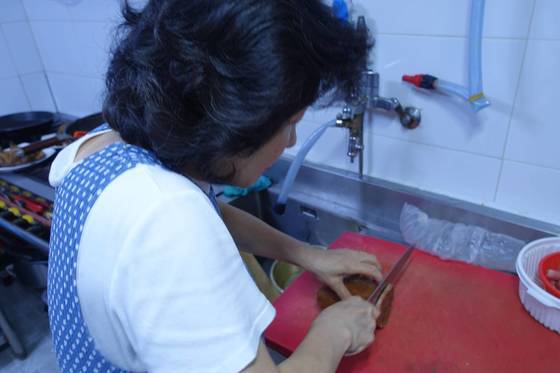 와다라면을 끓이기 위해 해삼내장 얼린 덩어리를 자르고 있다.