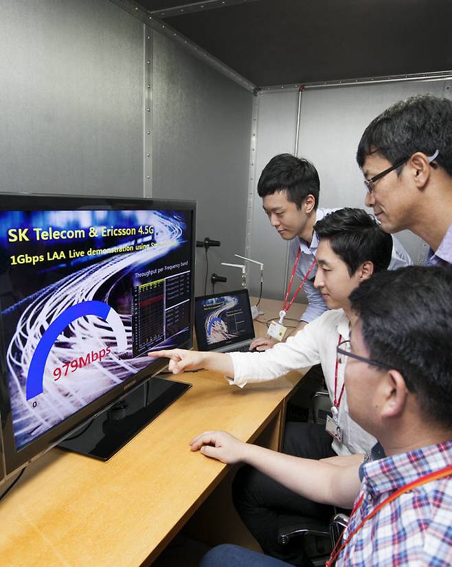 SK텔레콤과 에릭슨 엘지의 연구원들이 13일 SK텔레콤 분당 기술원에서 스마트폰에 LTE 주파수와 WiFi용 주파수를 함께 활용하는 '비면허대역 주파수 집성기술'(LAA: Licensed Assisted Access)을 적용해 1Gbps LTE 속도를 시연하고 있다.