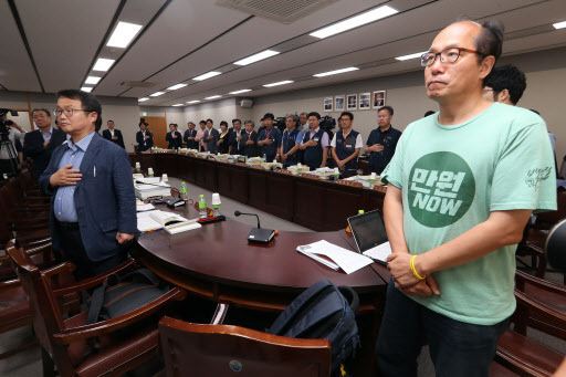 12일 정부세종청사 고용노동부에서 열린 최저임금위원회 제10차 전원회의에서 참석 위원들이 국기에 대한 경례를 하고 있다. [사진제공=연합뉴스]