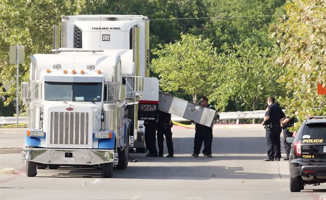 23일 미국 텍사스주 샌안토니오의 월마트 주차장에 세워진 트레일러에서 시신 8구와 부상자 30여명이 발견된 가운데 경찰들이 사고 현장을 조사하고 있다. 샌안토니오=EPA 연합뉴스