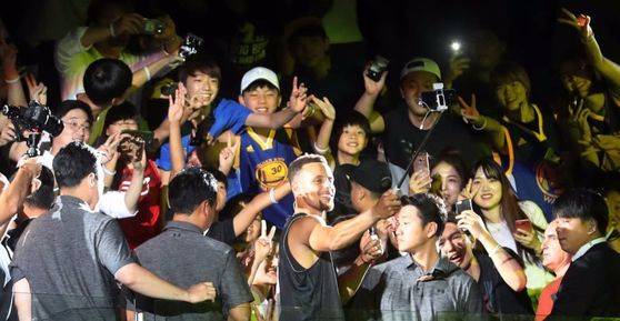 NBA 스타 스테판 커리(가운데)는 두 차례나 시즌 MVP를 차지할 만큼 최정상급 기량을 가졌다. 또한 선행에도 앞장서도 팬들과 적극적으로 소통하는 열린 마음의 소유자다. 27일 서울 장충체육관에서 열린 행사에서 팬들과 함께 셀카 촬영을 하는 커리. [연합뉴스]