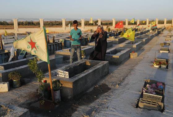 쿠르드족 시민이 IS와의 전투에서 희생된 친지의 무덤 앞에 섰다. [AP=연합뉴스]