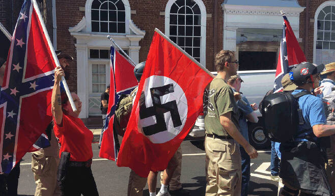12일 미국 버지니아주 샬러츠빌의 극우 백인민족주의자들의 행진에서 한 참가자가 나치 깃발을 들고 있다. 사진 출처:트위터