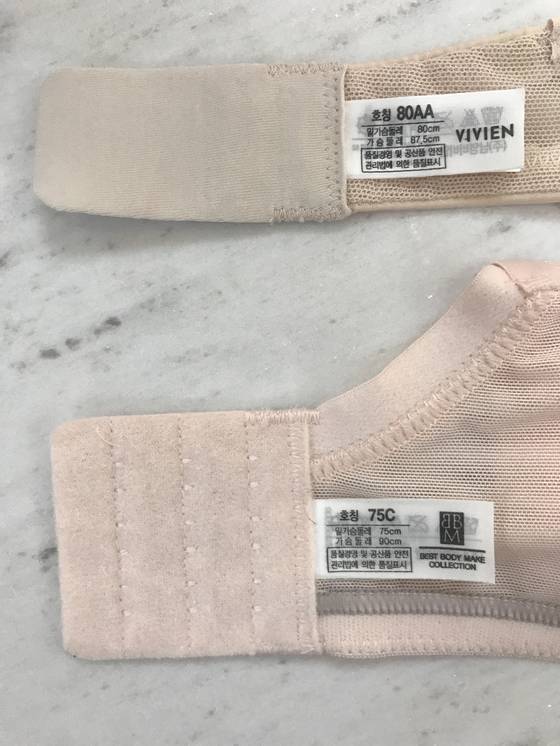 브래지어 안쪽에 보면 밑가슴둘레와 가슴둘레 사이즈가 모두 표기돼 있다. 이 차이로 컵을 결정한다. 가령 가슴둘레 87.5cm, 밑가슴둘레 80cm는 7.5cm차이로 80AA가 된다(위). [사진 비비안]
