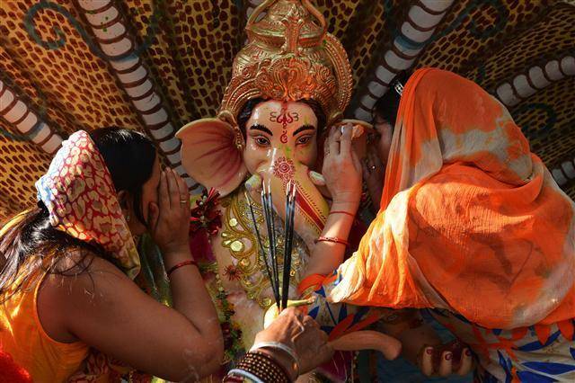 인도 힌두교 신자들이 27일(현지시간) 힌두 신 가네샤의 코끼리상을 바다에 담그기 전 기도를 올리고 있다. 매년 인도 전역에서 열흘간 열리는 가네샤 차투르티 축제는 지혜와 부귀를 가져다 주는 신으로 추앙받는 가네샤를 경축하는 축제다. [암리차르=AFP연합뉴스]