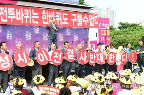 (화성=연합뉴스) '수원전투비행장 화성이전을 반대하는 범시민대책위원회'는 29일 서울 용산구 이태원로 국방부 맞은편 용산전쟁기념관 앞에서 대규모 집회를 열고 비행장 이전 반대 목소리를 높였다. 올해 4번째로 열린 이 날 국방부 상경집회에서 화성시민들이 피켓을 들고 구호를 외치고 있다. 2017.8.29 [화성시 제공=연합뉴스]      hedgehog@yna.co.kr