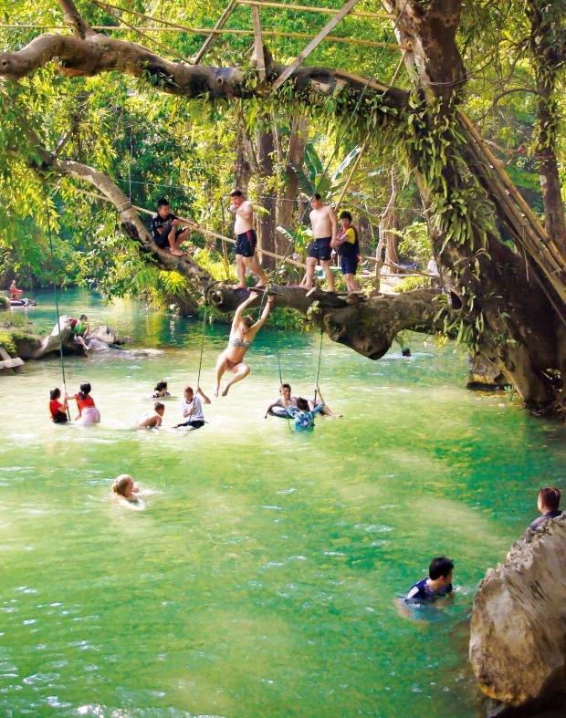 이름처럼 푸른 물빛이 아름다운 방비엥의 블루라군에서 여행객들이 물놀이를 즐기고 있다.