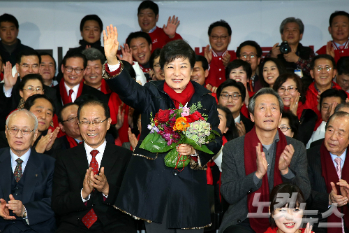 지난 2012년 12월 19일에 실시된 제18대 대통령선거에서 박근혜 대통령(당시 후보)가 당선이 확실시 되자 새누리당 당사 종합상황실을 찾아 캠프관계자로부터 꽃다발을 받고 손을 흔들고 있는 모습. (사진=황진환 기자)