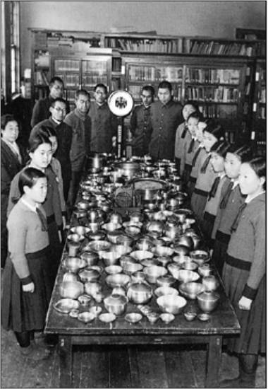 1942년 한 여학교에서 학부형들에게서 강제로 공출한 놋그릇을 한 곳에 모아놓고 교사와 학생들이 기념촬영을 하고 있다.