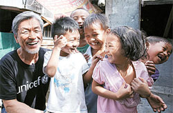 지난달 23일 필리핀 타클로반 태풍 피해현장을 방문한 소리꾼 장사익이 아이들과 즐거운 시간을 보내고 있다. [사진 한국유니세프]