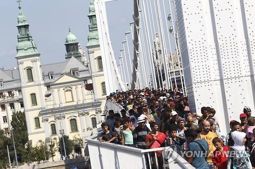 (부다페스트 AP=연합뉴스) 난민들이 오스트리아 국경까지 도보행진을 벌이고 있다.