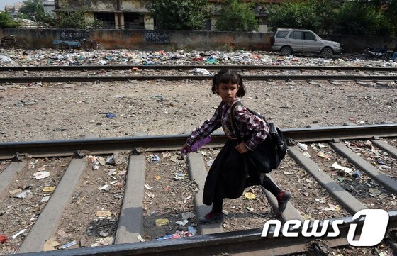 지난 9일 4세 여아가 집단 성폭행을 당한 후 숨진 인도 뉴델리 빈민가의 철로를 한 어린이가 걷고 있다.© AFP=뉴스1
