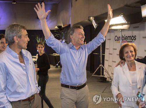 22일(현지시간) 치러진 아르헨티나 대통령선거 결선에서 투표를 행사한 야당의 마우리시오 마크리 후보가 지지자들에게 손을 들어 환호하고 있다.(AFP=연합뉴스)