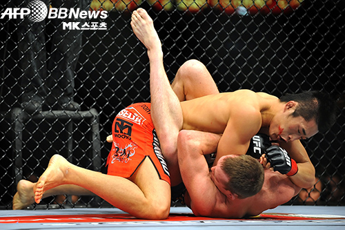 김동현(위)이 2009년 7월 11일 ‘UFC 100’에서 티제이 그랜트(아래)를 제압하고 있다. 김동현에게 만장일치 판정패를 당한 그랜트는 훗날 라이트급(-70kg) 1위가 됐으나 부상으로 타이틀전 기회를 놓치고 지금은 잠정은퇴상태다. 사진(미국 라스베이거스)=AFPBBNews=News1