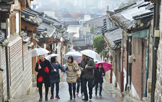 지난 29일 오전 서울 종로구 북촌한옥마을에서 겨울비를 맞은 관광객들이 우산을 쓰고 한옥마을을 둘러보고 있다. / 사진=뉴스1