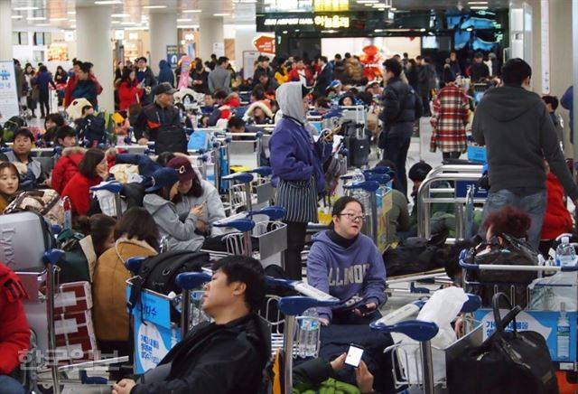 24일 출발 예정된 모든 항공편이 결항된 제주국제공항에 수백명의 승객이 대기 발권을 기다리고 있다.