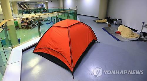 <최강한파> 텐트까지 친 체류객들 (제주=연합뉴스) 변지철 기자 = 사상 초유의 제주공항 항공기 중단 사태가 3일째 이어진 25일 새벽 고단 하루를 마친 체류객들이 제주공항 여객터미널에 텐트를 치고 잠을 자고 있다. 2016.1.25 bjc@yna.co.kr