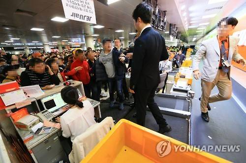 (제주=연합뉴스) 박지호 기자 = 항공기 운항이 재개된 25일 오후 제주공항 국내선 출발층 수속장에서 기다리다 지친 승객들이 항공사 직원들에게 강하게 항의하고 있다. 2016.1.25 jihopark@yna.co.kr