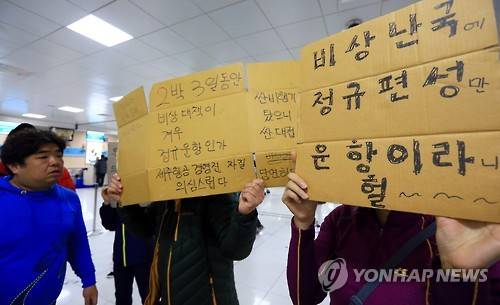 시위 나선 제주공항 체류객 (제주=연합뉴스) 고성식 기자 = 제주공항의 항공기 운항이 재개된 25일 오후 제주항공 이용객들이 임시편 추가 투입을 요구하는 내용의 글을 적어 항공사에 항의하고 있다. 2016.1.25 koss@yna.co.kr