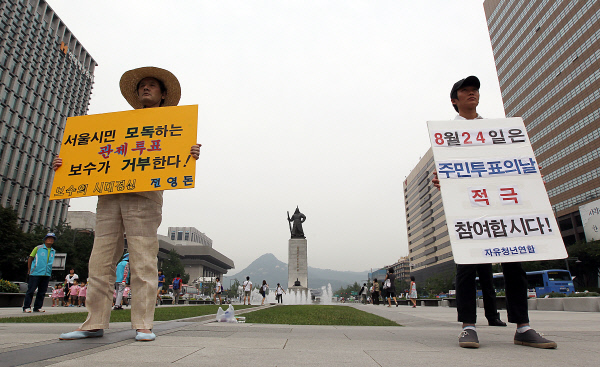 2011년 8월22일 오후 서울 광화문광장에 무상급식 주민투표에 관해 엇갈린 입장을 가진 시민 두 명이 함께 1인 피켓 캠페인을 벌이고 있다. ｜연합뉴스