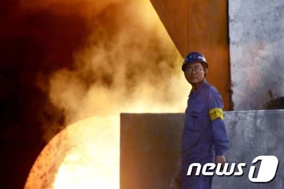 중국 북부 허베이성의 한스틸 제철소에서 한 노동자가 걸어가고 있다.2016.4.21© AFP=뉴스1