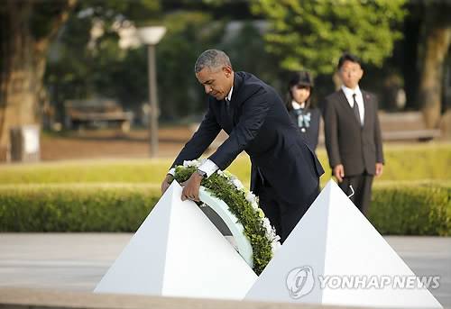 71년만의 헌화 (히로시마 AP=연합뉴스) 버락 오바마 미국 대통령(가운데)이 27일(현지시간) 일본의 2차대전 피폭지인 히로시마를 방문, 히로시마평화기념공원에서 헌화하고 있다. 오바마 대통령은 1945년 8월 6일 미국이 히로시마에 원자폭탄을 떨어뜨린 지 71년 만에 현직 미국 대통령으로는 처음으로 이날 히로시마를 찾았다.