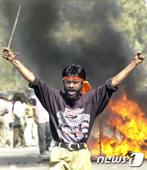 2002년 2월 인도 구자라트주(州) 아마다바드에서 발생한 폭동 당시 한 인도 활동가가 쇠 몽둥이를 들고 반(反)무슬림 슬로건을 외치고 있다.  ©AFP= News1