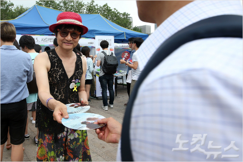 11일 오후 서울광장에서 열린 ‘제17회 퀴어문화축제’ 에 참가한 김조광수 감독이 유인물을 나눠주고 있다. 황진환기자