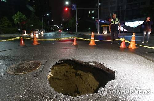 제2롯데월드 인근 도로서 또 지반침하 (서울=연합뉴스) 서명곤 기자 = 최근 싱크홀과 지반 침하 현상이 잇따랐던 서울 송파구 제2롯데월드 주변에서 지반침하 현상이 또 발생했다. 5일 서울 송파구 신천동 파크리오아파트 사거리 중심 도로에서 지름 1m 크기의 원모양 구멍이 생겼다. 6일 새벽 경찰이 구멍 근처에 폴리스 라인을 설치해두고 있다. 2016.7.6 seephoto@yna.co.kr