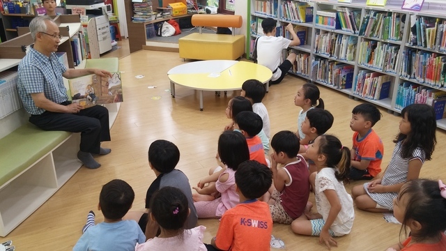 독산4동 주민센터 2층에 자리잡은 어린이도서관에서 아이들에게 책을 읽어주는 할아버지의 모습.