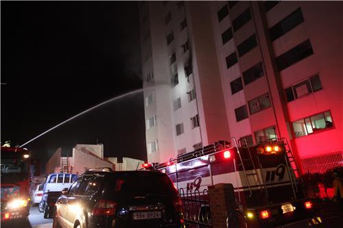 30일 오후 9시 2분께 부산 기장군 기장읍에 있는 9층짜리 아파트 5층에서 원인이 밝혀지지 않은 불이 나 출동한 소방차가 물을 쏘고 있다. [부산 기장소방서 제공]