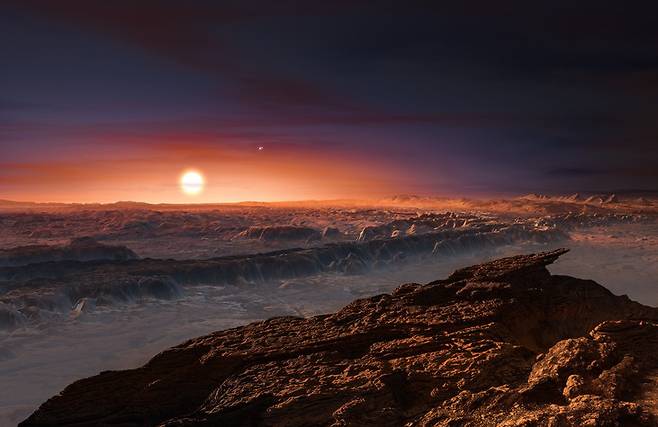 생명체가 존재할 가능성이 있는 가장 가까운 외계 행성 프록시마 비(b)의 지표면 모습(상상도)이다. 그림에 보이는 해는 태양계로부터 가장 가까운 별 ‘프록시마 켄타우리’이다.  <네이처> 제공