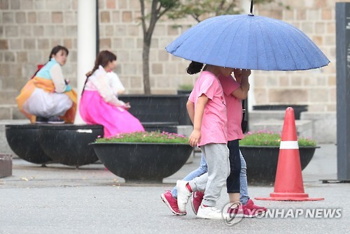 서울 일부 지역에 소나기가 내려 경복궁을 찾은 어린이들이 우산을 나눠쓰고 있다. [연합뉴스 자료사진]