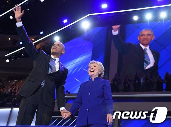 버락 오바마 미국 대통령(왼쪽)이 클린턴 후보의 손을 잡고 환하게 웃고 있다. © AFP=뉴스1