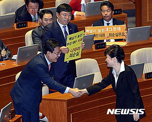 【서울=뉴시스】박진희 기자 = 24일 서울 여의도 국회 본회의장에서 박근혜 대통령이 시정연설을 마치고 단상에서 내려오고 있다. 박대통령 뒷편으로 울산출신 무소속 김종훈, 윤종오 의원이 '나와라 최순실'이라고 적힌 손팻말을 들고 있다. 2016.10.24. photo@newsis.com