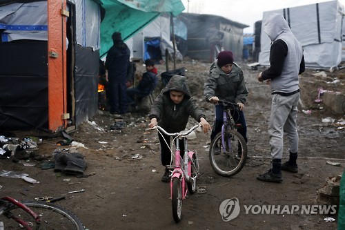 지난 2월 프랑스 칼레 난민촌에서 자전거를 타고 있는 아프가니스탄 출신의 난민 어린이들 [AP=연합뉴스]