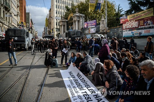 26일 '이스탄불의 명동' 이스티클랄 거리에서 쿠르드계 시장 구금을 비판하는 시위가 열렸다. 시위대는 "자치단체는 주민의 것이다. 주민을 쓰러뜨릴 수 없다"고 쓰인 플래카드를 펼쳐놓고 있다.[AFP=연합뉴스]