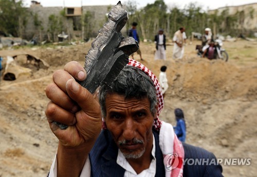 공습 후 로켓 파편을 들고 있는 예멘인 [EPA=연합뉴스]