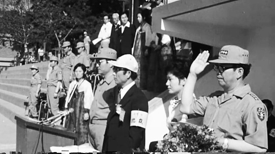 최태민씨(오른쪽 세 번째)와 영애 시절 박근혜 대통령이 1975년 6월 21일 서울 서대문구 배재고 운동장에서 열린 구국십자군 창군식에 참석해 단상 위에 나란히 서 있다. 대한뉴스 동영상 캡처