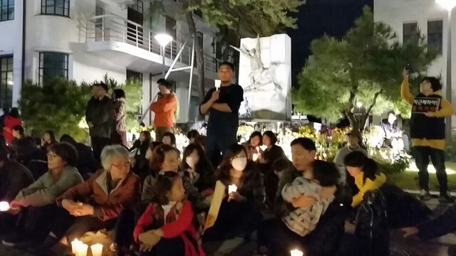 12일 밤 80년 5.18항쟁의 시민군 거점이었던 옛 전남도청(현 국립아시아문화전당)에 서있는 5.18기념탑앞에서 시민들이 촛불을 들고 서있다.