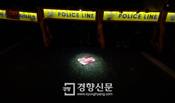 19일 서울 광화문광장 인근 촛불시위 현장에서 경찰이 설치한 폴리스라인 앞에 떨어진 ‘박근혜 퇴진’ 손팻말. 이준헌 기자