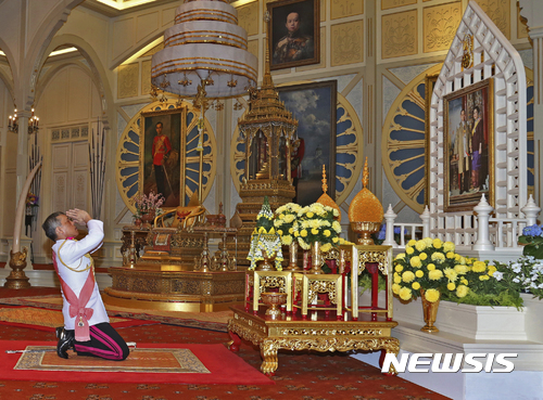 【방콕=AP/뉴시스】마하 와치랄롱꼰 태국 새국왕이 1일 방콕 왕궁에서 서거한 선왕 푸미폰 아둔야뎃 국왕부처의 사진에 절을 하며 경의를 표시하고 있다. 마하 와이랄롱꼰 국왕은 이날 '라마 10세'로 정식 즉위했다. 2016.12.02