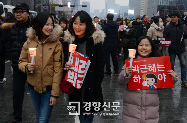 박근혜정권 퇴진을 위한 5차 촛불집회가 열린 11월 26일 서울 광화문광장에서 한 가족이 촛불을 들고 행진하고 있다. / 서성일 기자