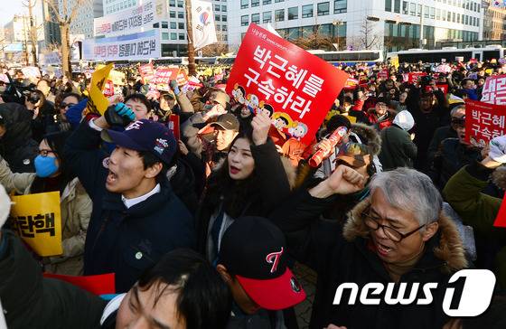 박근혜 대통령의 탄핵안이 가결된 9일 오후 서울 여의도 국회 앞에서 시민들이 환호하고 있다. 이날 박 대통령의 탄핵안은 299명의 국회의원이 참여해 찬성 234표, 반대 56표, 기권 2표, 무효 7표로 가결됐다. 2016.12.9/뉴스1 © News1 최현규 기자