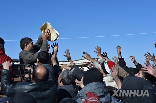 9일 알레포 지브린 캠프에서 구호단체가 알레포 피난민에게 빵을 나눠주고 있다. [신화=연합뉴스]
