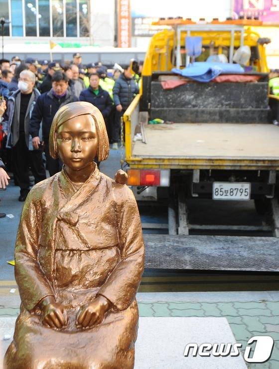 28일 오후 부산 동구 일본영사관 앞에서 부산시민단체 회원들이 설치한 일본위안부 소녀상을 동구청 직원들이 철거하고 있다. 지난해 한일 정부의 위안부 합의에 반발한 부산시민단체가 일본영사관 앞에 소녀상을 설치했으나 관할 부산 동구가 설치 4시간만에 소녀상을 철거했다. 2016.12.28/뉴스1 © News1 여주연 기자